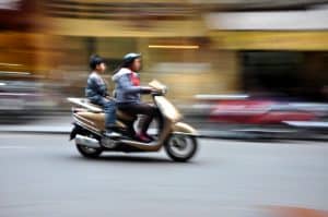Guldfarvet scooter i fart op bytrafikken