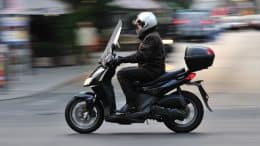Mand på scooter med beskyttelseshjelm